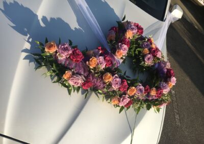 Rosengesteck mit unterschiedlichen Rosen auf einem weißen Mercedes