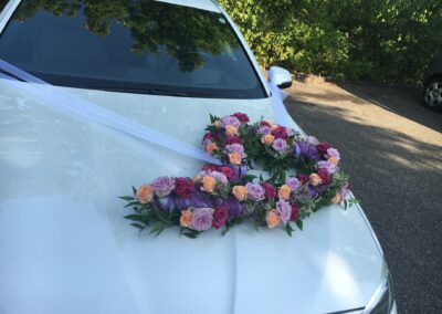 Rosengesteck mit unterschiedlichen Rosen auf einem weißen Mercedes