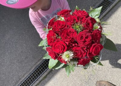 Rotes Blumengesteck, gehalten von einem Kund